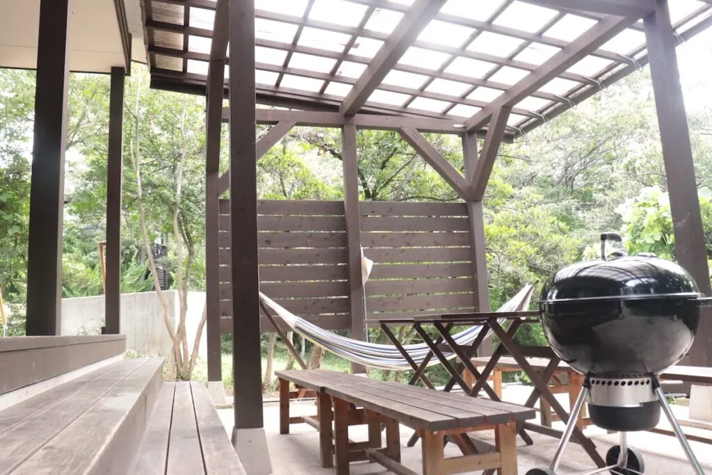 BBQグリルとハンモックのある屋根付きテラス