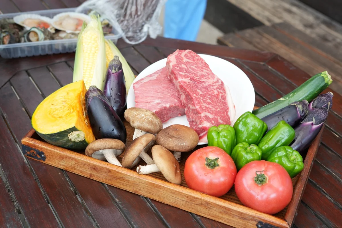 BBQテーブルに置かれた肉と野菜の食材トレイ